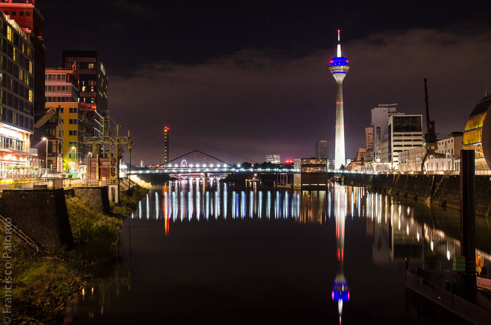 Hafenbecken bei Nacht, der Rheinturm spiegelt sich im Wasser